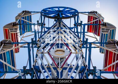 The zipper ride at a carnival against a blue sky. Stock Photo