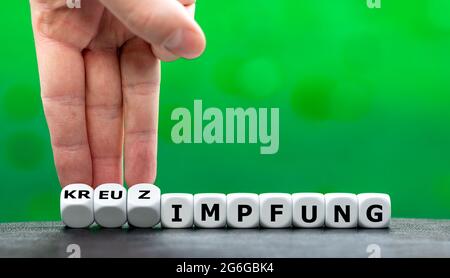 Symbol for a vaccination against covid 19 with two different vaccines. Dice form the German expression 'Kreuzimpfung' (cross vaccination). Stock Photo