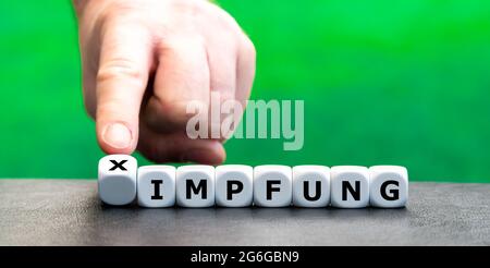 Symbol for a vaccination against covid 19 with two different vaccines. Dice form the German expression 'x Impfung' (cross vaccination). Stock Photo