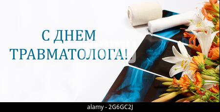 Greeting card with flowers and X-rays and inscription on the Russian On the day of the traumatologist. Stock Photo