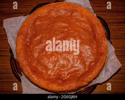 Top view of homemade freshly baked stuffed cheesecake on a glass tray and baking paper Stock Photo