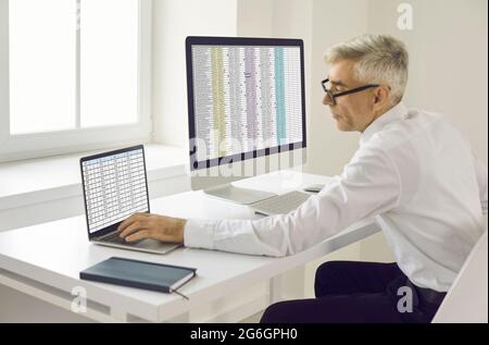 Senior businessman calculating electronic invoice. Stock Photo
