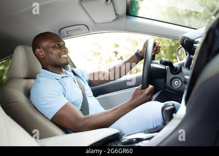 Joyful black man enjoying his new luxury car Stock Photo