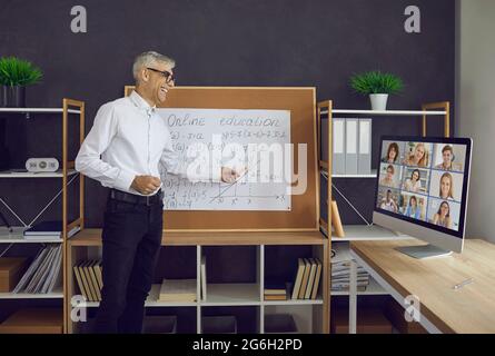 The senior male teacher conducts a class on the principle of online education with his students. Stock Photo