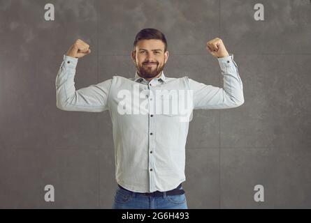 Confident handsome man office worker showing strong muscle looking at camera Stock Photo