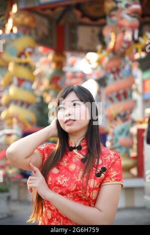 beauty woman wear red cheongsam looking and smile in chinese new year Stock Photo