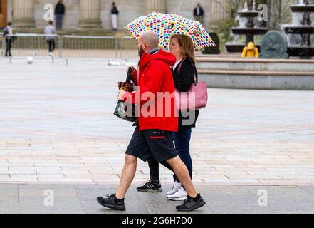 Dundee, Tayside, Scotland, UK. 6th July, 2021. UK Weather: A cloudy and wet day with outbreaks of light rain across North East Scotland with temperatures reaching 17°C. Local residents are still well aware of the social distancing guidelines and the wearing of face masks whilst outside. Shoppers who are caught out in the sudden downpours are sheltering underneath their brollies whilst out shopping in Dundee city centre. Credit: Dundee Photographics/Alamy Live News Stock Photo