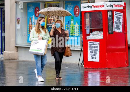 Dundee, Tayside, Scotland, UK. 6th July, 2021. UK Weather: A cloudy and wet day with outbreaks of light rain across North East Scotland with temperatures reaching 17°C. Local residents are still well aware of the social distancing guidelines and the wearing of face masks whilst outside. Shoppers who are caught out in the sudden downpours are sheltering underneath their brollies whilst out shopping in Dundee city centre. Credit: Dundee Photographics/Alamy Live News Stock Photo