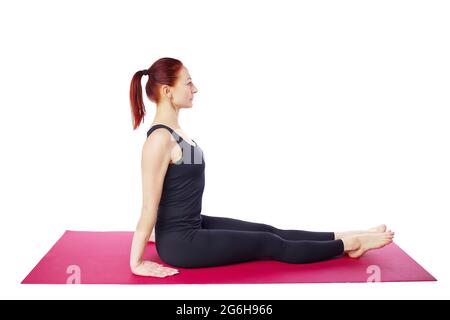 This slender middle-aged woman shows the starting position for performing exercises on a gym mat. Isolated on a white background. Stock Photo