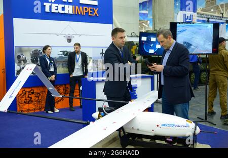 Two managers standing in front of the military unmanned aerial vehicles presented on a stand and discuss it. Exhibition Arms and Safety. October 08, 2 Stock Photo