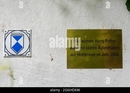 Hiddensee, Germany. 24th June, 2021. On a house in Kloster hangs a brass plaque with the inscription: 'Harry Potter lived here during his stay on Hiddensee in 2000'. Next to it is the sign for listed buildings. Credit: Stephan Schulz/dpa-Zentralbild/ZB/dpa/Alamy Live News Stock Photo