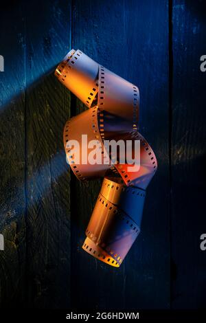 Color Film Roll on Black Wood with Colored Lights Stock Photo