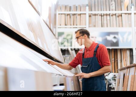 sales consultant inspecting samples of floor coverings. Stock Photo
