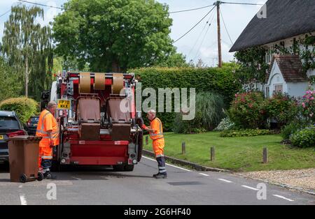 Hampshire, England, UK. 2021. Council operatives collect garden waste bins which are transported in the truck to be composted, bagged, sold as compost Stock Photo