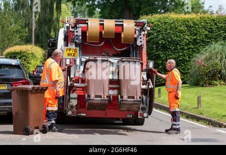 Hampshire, England, UK. 2021. Council operatives collect garden waste bins which are transported in the truck to be composted, bagged, sold as compost Stock Photo