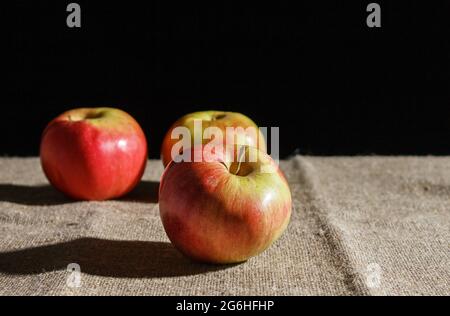 three red apples on the table. closeup on black background Stock Photo