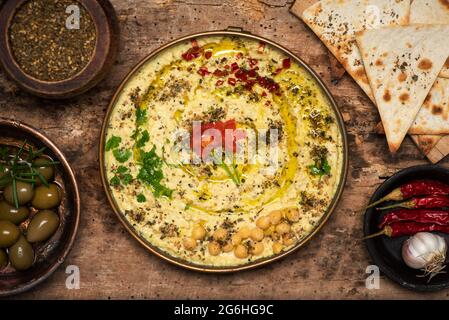 Hummus dipping sauce made of chickpeas, sesame and other ingredients, traditionally used in Mediterranean and Middle Easter cuisines, served in a bowl Stock Photo