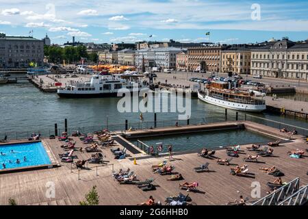 People sun bathing on Allas Sea Pool floating pool deck in Helsinki, Finland Stock Photo