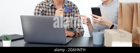 Shopping online concept a couple choosing recommended products with appealing promotions shown in online shop on a tablet device. Stock Photo