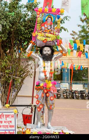 A unidentified man painted his body with silver colour and holding a picture of lord Krishna posed as Vasudeva. Kolkata, West Bengal, India on Decembe Stock Photo