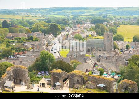 Corfe Castle, UK - June 24 2021: Aerial view of the quaint, historic medieval village of Corfe Castle, Dorset, England on a summer day. Stock Photo