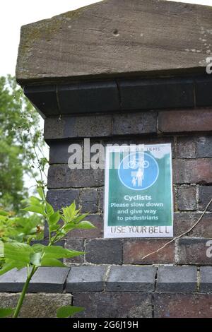 Sign for cyclists: 'Cyclists please slow down and give way to pedestrians'. Stock Photo