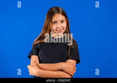 Portrait of her she nice-looking cute lovely attractive cheerful cheery straight-haired blonde girl folded arms copy space isolated on blue background Stock Photo