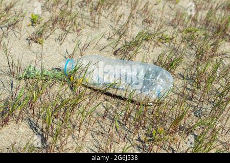 Waste plastic water bottle on the beach.Beat Plastic Pollution.beach pollution.plastic bottles on sea beach.ecological concept.Close-up bottle plastic. Stock Photo