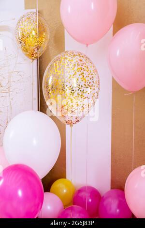 Pink and white baloons at reception hall.Balloons filled with helium,white and gold colors,tied with golden ribbons.Flying balls, as an essential Stock Photo