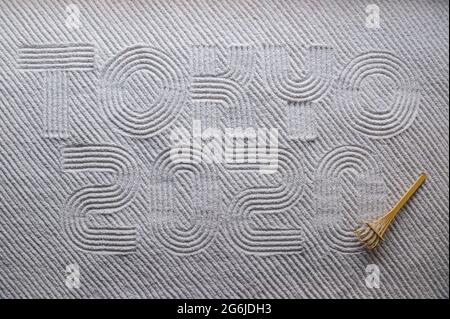 MIAMI, USA - August, 2019: Japanese Zen garden raked with the word TOKYO 2020 in capital letters in textured white sand with diagonal pattern and wood Stock Photo