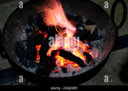 Burning charcoal in an iron stove for home heating. Red burnt