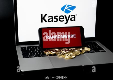 Smartphone with RANSOMWARE words and blurred bitcoins and Kaseya logo on laptop. Concept for ransomware attack and security breach.  Stafford, United Stock Photo