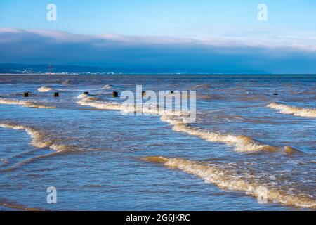 Rolling waves breaking on the shore at Dymchurch beach Stock Photo