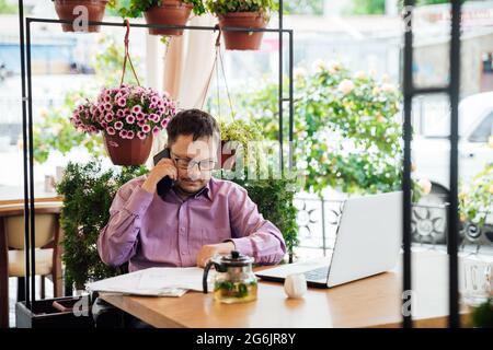 disabled man with wheelchair in restaurant eating Stock Photo