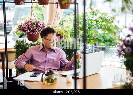 disabled man with wheelchair in restaurant eating Stock Photo