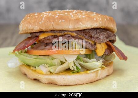 Double patty cheeseburger hamburger will fill any appetite with lettuce, bacon, tomato, and sauce for the fillings. Stock Photo
