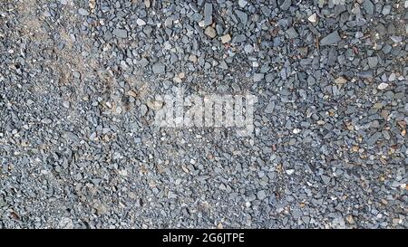 Granite gravel, stones, crushed stone close-up. Rough seamless texture, construction material background. Stock Photo