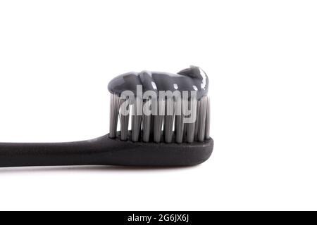 Black Toothbrush with Black Activated Charcoal Toothpaste on a White Background Stock Photo