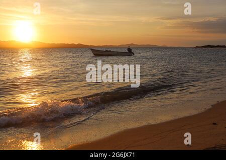 Un Bote de pesca flota en el agua atardecer en la playa de frente  Isla del Tiburon en la localidad de Punta Chueca durante la celebración año nuevo Seri en la comunidad de Punta Chueca el 30 junio 2021 en Hermosillo, Mexico.(Foto by Luis Gutierrez / Norte Photo )  A fishing boat floats in the sunset water on the beach in front of Isla del Tiburon in the town of Punta Chueca during the Seri New Year celebration in the community of Punta Chueca on June 30, 2021 in Hermosillo, Mexico. (Photo by Luis Gutierrez / North Photo) Stock Photo