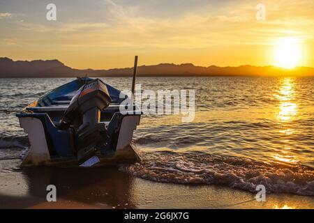 Un Bote de pesca flota en el agua atardecer en la playa de frente  Isla del Tiburon en la localidad de Punta Chueca durante la celebración año nuevo Seri en la comunidad de Punta Chueca el 30 junio 2021 en Hermosillo, Mexico.(Foto by Luis Gutierrez / Norte Photo )  A fishing boat floats in the sunset water on the beach in front of Isla del Tiburon in the town of Punta Chueca during the Seri New Year celebration in the community of Punta Chueca on June 30, 2021 in Hermosillo, Mexico. (Photo by Luis Gutierrez / North Photo) Stock Photo