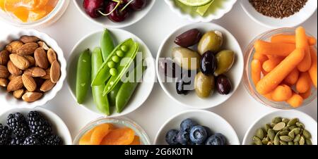 Top down close up view of small dishes filled with various healthy raw ingredients, against a white background. Stock Photo