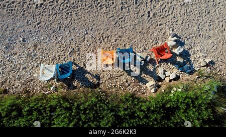 Aerial view from above of a group of colorful adirondack chairs on a beach at sunset in Door County, Egg Harbor, Wisconsin, USA Stock Photo