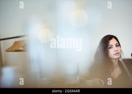 Hamburg, Germany. 12th June, 2021. Yusra Mardini, a swimmer, sits in a meeting room of a Hamburg hotel during an interview. In the foreground, glasses are reflected on the table. Credit: Gregor Fischer/dpa/Alamy Live News Stock Photo