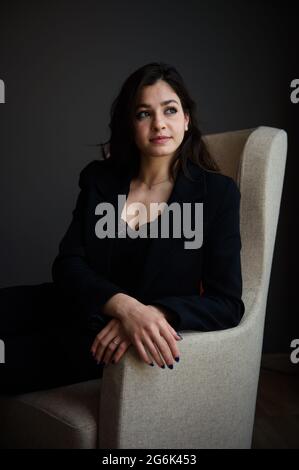 Hamburg, Germany. 12th June, 2021. Yusra Mardini, a swimmer, is sitting in an armchair next to a window in the lounge of a Hamburg hotel. Credit: Gregor Fischer/dpa/Alamy Live News Stock Photo