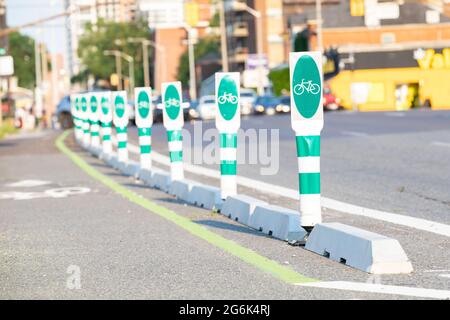 Safety barriers for bicycle lanes on the street, selective focus on the front green post with soft focus background. Stock Photo