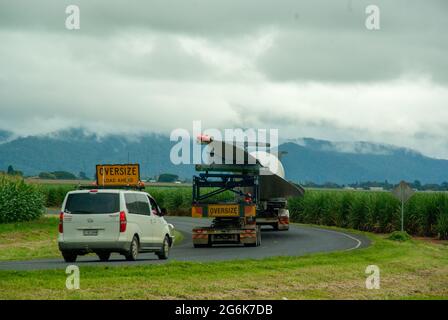 Wind Turbine Blade being transported by truck. Atherton Tablelands bound for Mount Edith Windfarm. Escort vehicles in attendance. Passing through maiz Stock Photo