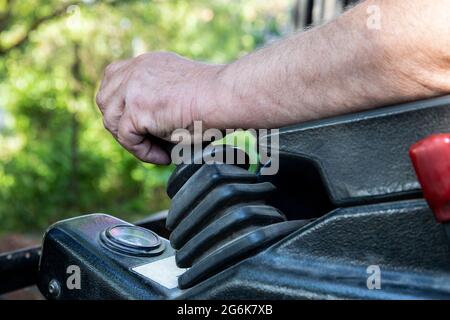Man's hand on the control lever of a mini excavator. Stock Photo