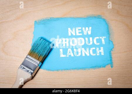 New Product Launch. Blue painted area and brush on a wooden background. Stock Photo