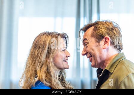Mature man and woman looking at each other at home. Stock Photo