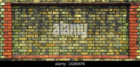 An old weathered section of yellow brick wall is framed by red bricks Stock Photo